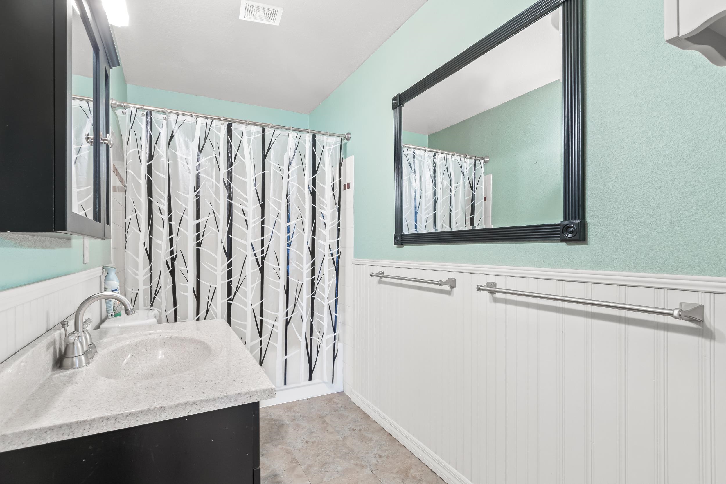 110 Harvard Road St. Augustine, FL 32086 - Photo 29 of 42 a bathroom with a sink vanity and a mirror