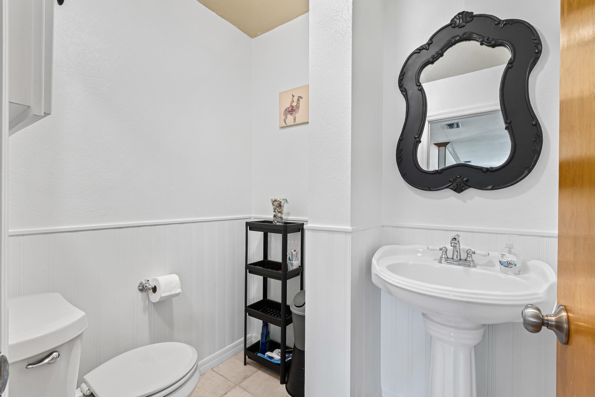 110 Harvard Road St. Augustine, FL 32086 - Photo 38 of 42 a bathroom with a toilet sink and mirror