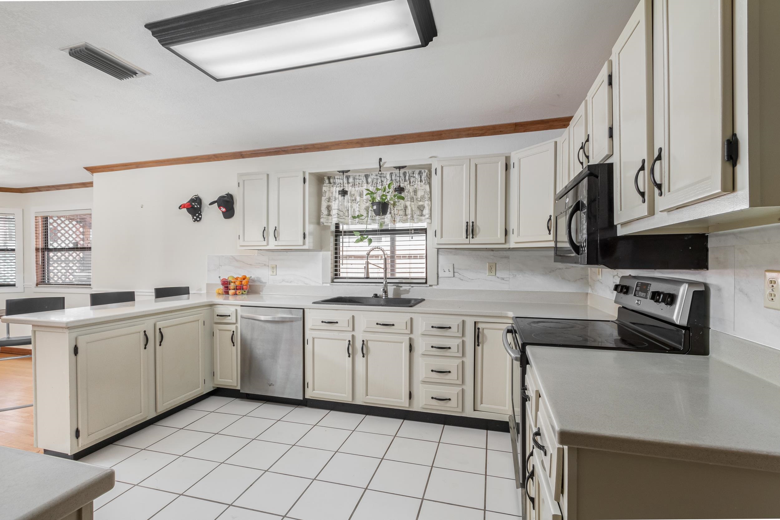 110 Harvard Road St. Augustine, FL 32086 - Photo 40 of 42 a kitchen with white cabinets a sink and white appliances