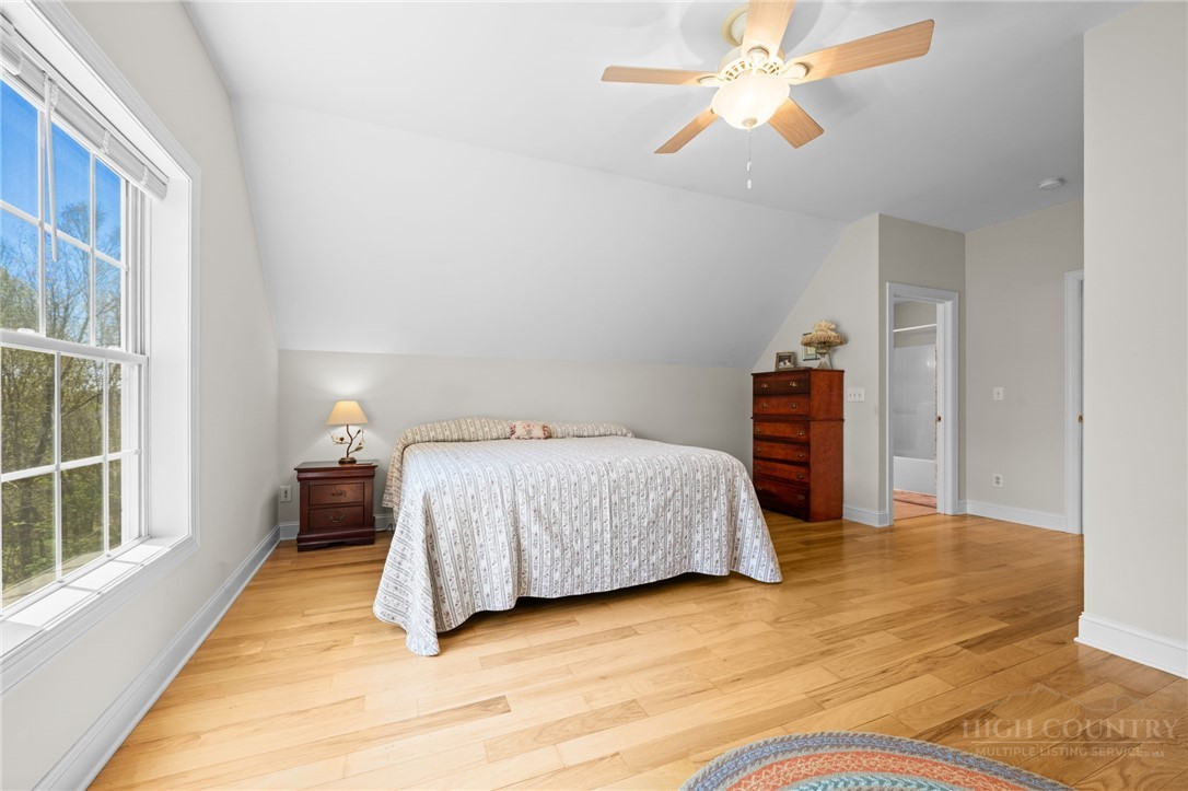 982 Brown's Chapel Road Boone, NC 28607 - Photo 24 of 42 a bedroom with a bed and a chandelier
