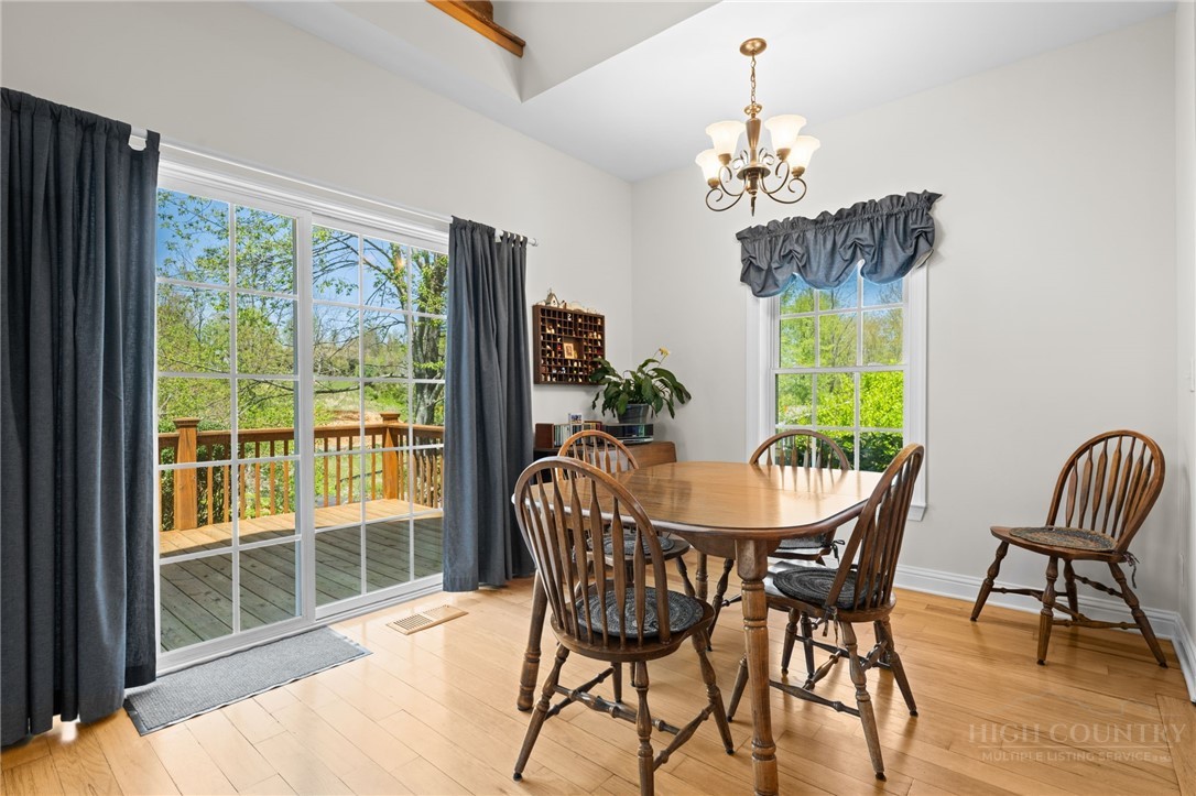 982 Brown's Chapel Road Boone, NC 28607 - Photo 6 of 42 a dining room with furniture a chandelier and wooden floor