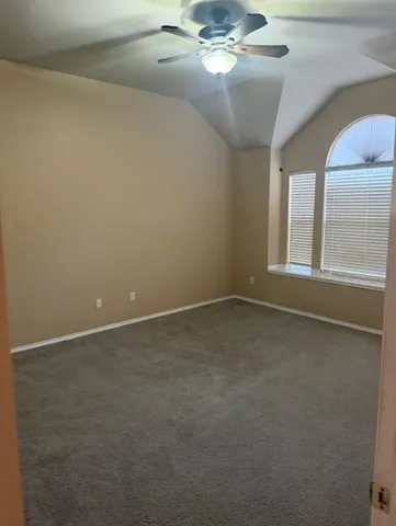 a view of an empty room with a chandelier fan