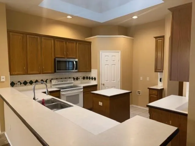 a kitchen with stainless steel appliances a stove a sink and a microwave