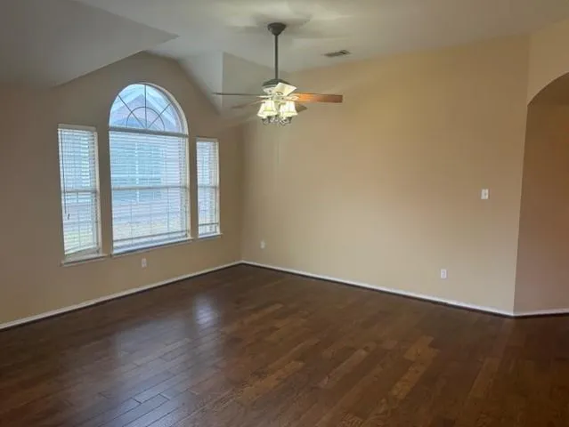 a view of wooden floor chandelier and window in an empty room