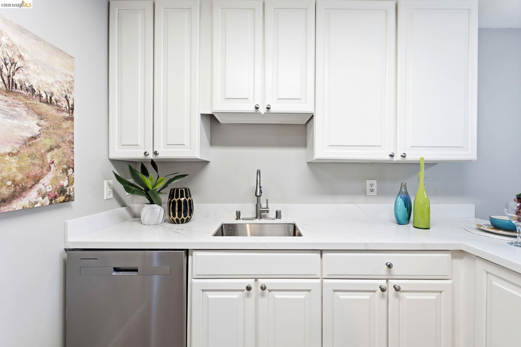 4081 Clayton Road, Unit 209 Concord, CA 94521 - Photo 13 of 47 Kitchen featuring white shaker-style cabinetry, a stainless steel sink with a gooseneck faucet, light-colored countertops, and a stainless steel dishwasher
