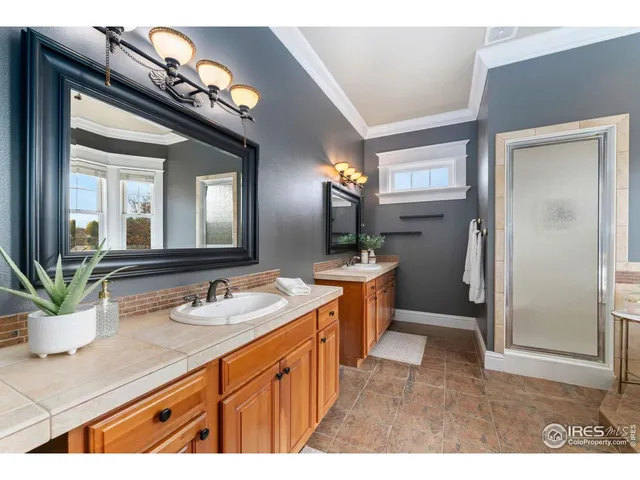 a spacious bathroom with a sink a mirror and a shower