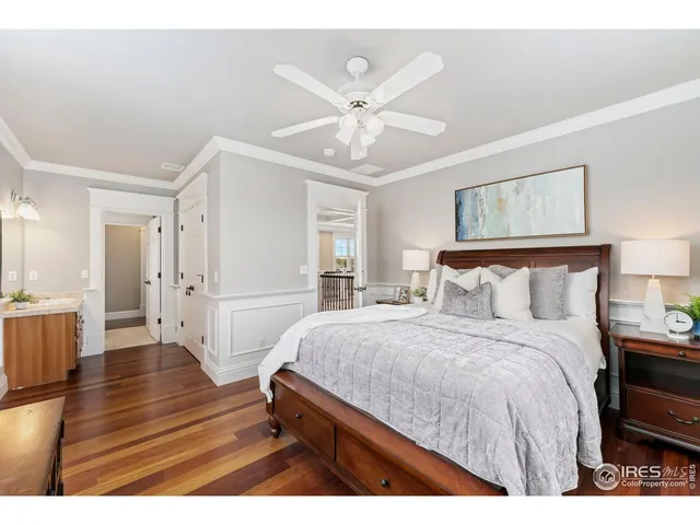 a bedroom with a bed and dresser with wooden floor