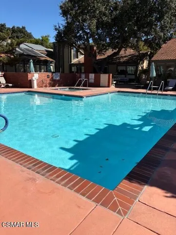 a view of a patio with table and chairs under an umbrella