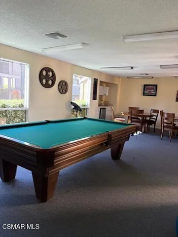 a room with pool table and a large window