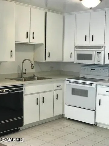 a kitchen with granite countertop white cabinets and stainless steel appliances