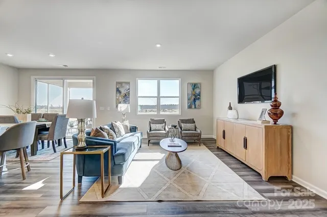 a living room with furniture a window and a flat screen tv