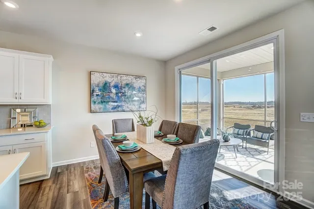 a dining room with furniture a rug and wooden floor