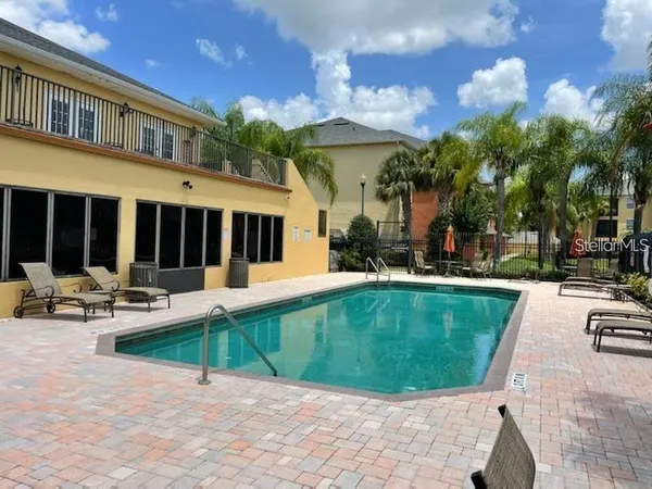 a view of a house with sitting area and swimming pool