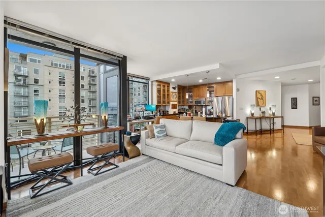 a living room with furniture a wooden floor and a large window