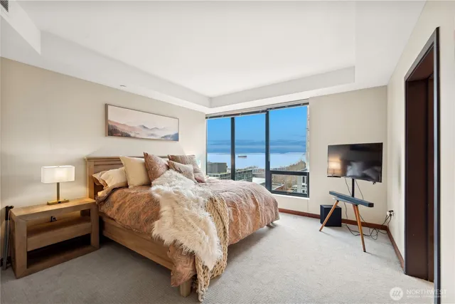 a bedroom with a large window and a bed