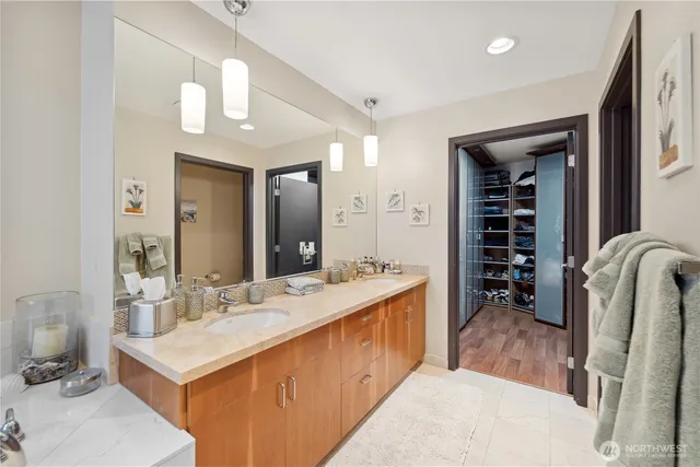 a bathroom with a double vanity sink a mirror and a bathtub