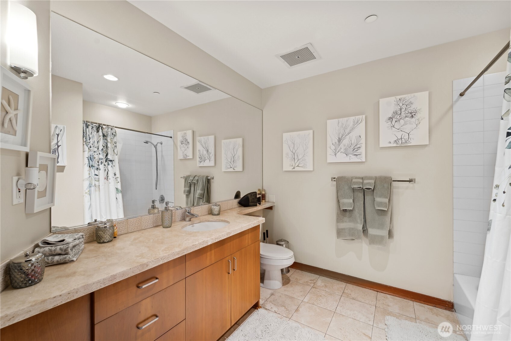 2716 Elliott Avenue, Unit 800 Seattle, WA 98121 - Photo 28 of 40 a bathroom with a double vanity sink a mirror and a bathtub