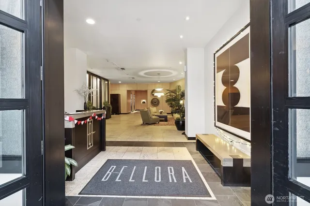 a living room with couches and kitchen view with wooden floor
