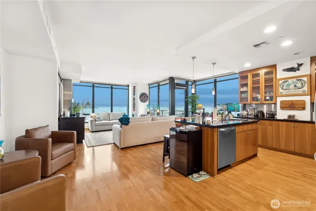 a living room with stainless steel appliances kitchen island granite countertop a stove a sink and a refrigerator