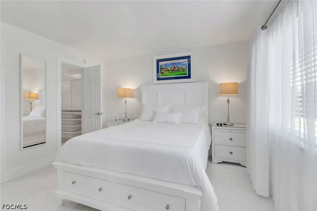 9 High Point Circle North, Unit 102 Naples, FL 34103 - Photo 15 of 48 a bedroom with a bed and a painting on the wall