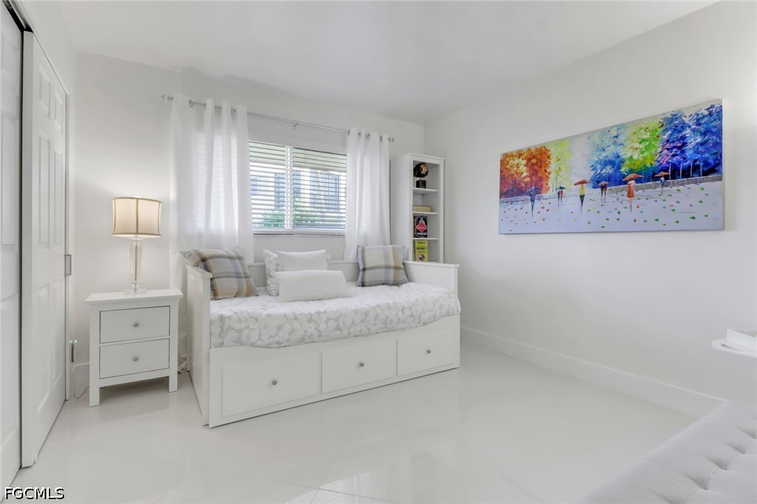 9 High Point Circle North, Unit 102 Naples, FL 34103 - Photo 21 of 48 a spacious bedroom with a bed and a window