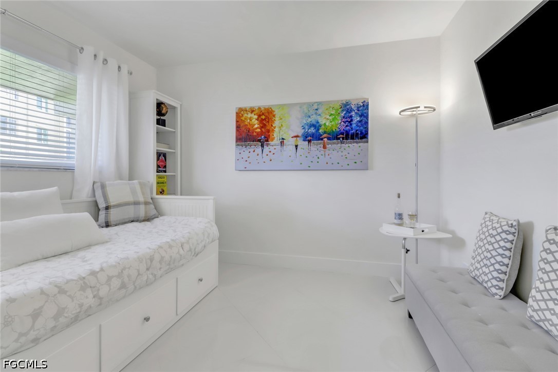 9 High Point Circle North, Unit 102 Naples, FL 34103 - Photo 22 of 48 a spacious bedroom with a bed and a flat screen tv