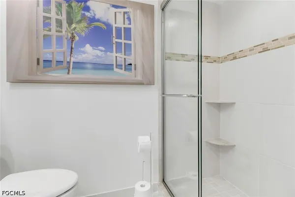 a bathroom with a granite countertop shower and a toilet