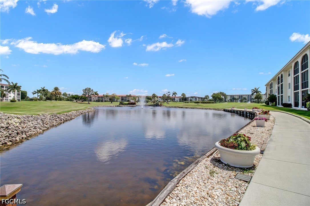 9 High Point Circle North, Unit 102 Naples, FL 34103 - Photo 27 of 48 a view of a lake with a patio and a lake view