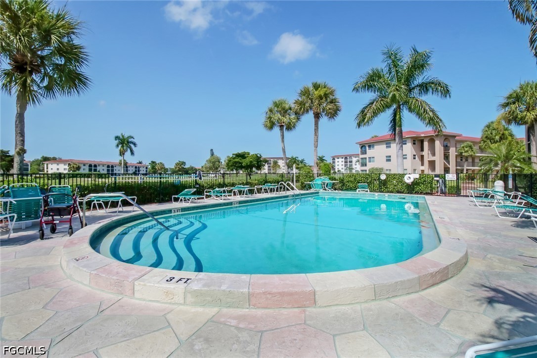 9 High Point Circle North, Unit 102 Naples, FL 34103 - Photo 28 of 48 a swimming pool with outdoor seating and yard