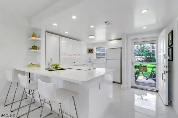 a kitchen with kitchen island a counter top space a sink stainless steel appliances and cabinets
