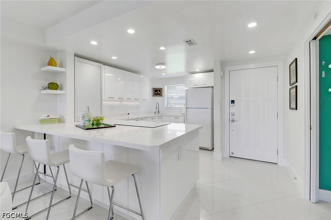 9 High Point Circle North, Unit 102 Naples, FL 34103 - Photo 4 of 48 a kitchen with a sink cabinets and stainless steel appliances
