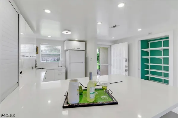 a kitchen with stainless steel appliances kitchen island granite countertop a refrigerator and a sink