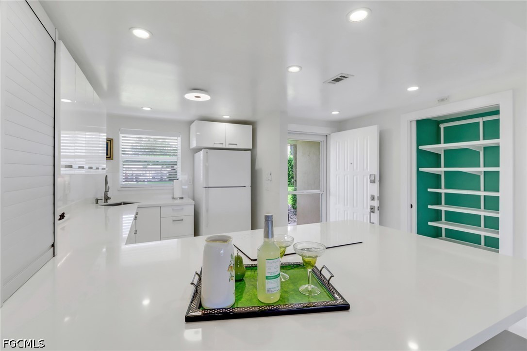 9 High Point Circle North, Unit 102 Naples, FL 34103 - Photo 5 of 48 a kitchen with stainless steel appliances kitchen island granite countertop a refrigerator and a sink