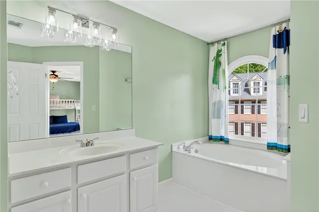 a bathroom with a tub sink and mirror