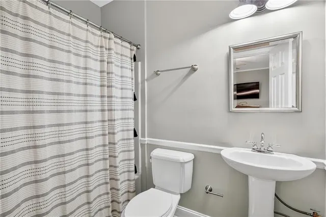 a bathroom with a sink toilet and mirror