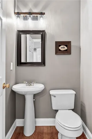 a bathroom with a toilet a sink and mirror