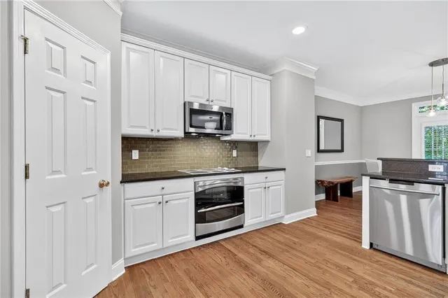 a kitchen with stainless steel appliances granite countertop a stove a sink and a microwave
