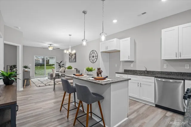 a kitchen with stainless steel appliances granite countertop counter space a dining table and chairs