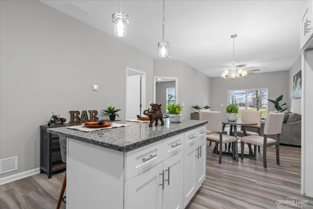 a kitchen with center island table and chairs