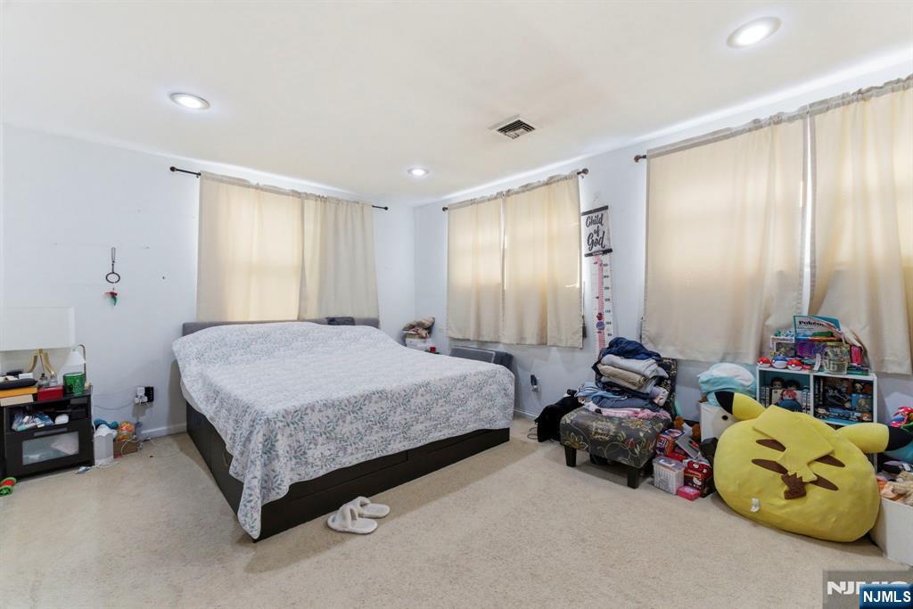 270 Westervelt Place Lodi, NJ 07644 - Photo 7 of 17 a spacious bedroom with two beds and a chandelier