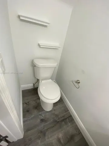 a white toilet sitting next to a shower