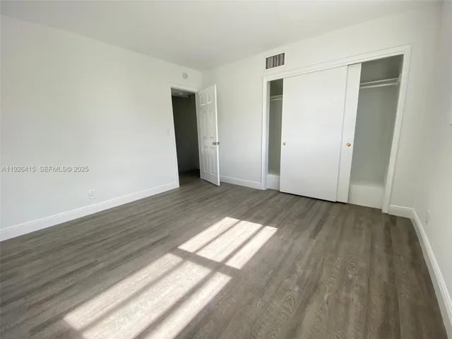 a view of an empty room and wooden floor