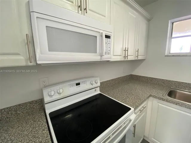 a kitchen with microwave and cabinets