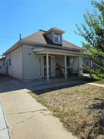 a view of a white house with large windows next to a yard