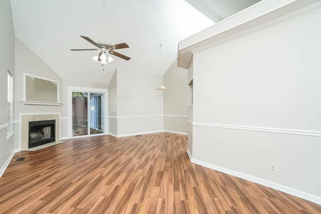 a view of empty room with wooden floor and fireplace