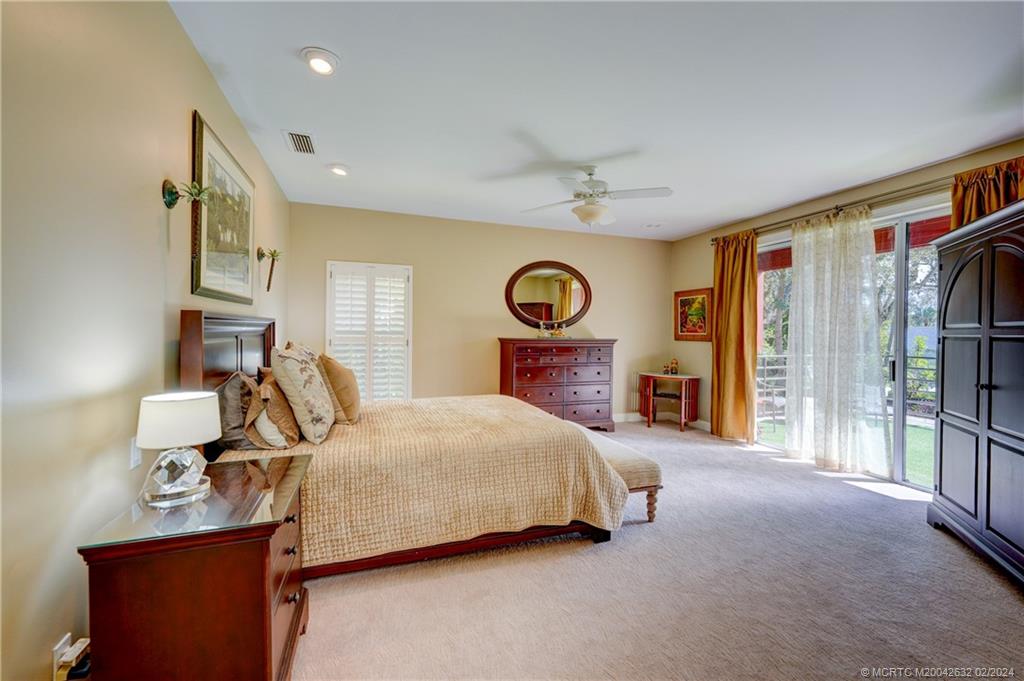 132 South River Road Stuart, FL 34996 - Photo 16 of 45 a bedroom with a bed and a chandelier