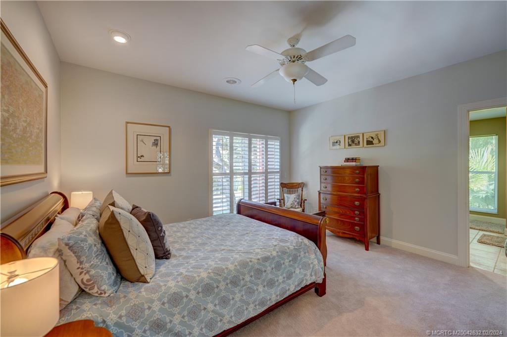 132 South River Road Stuart, FL 34996 - Photo 29 of 45 a bedroom with a bed and dresser with mirror