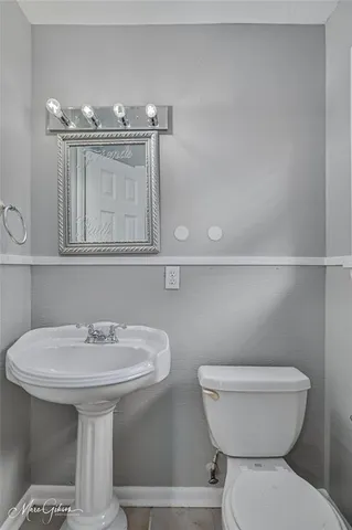 a bathroom with a toilet a sink and mirror