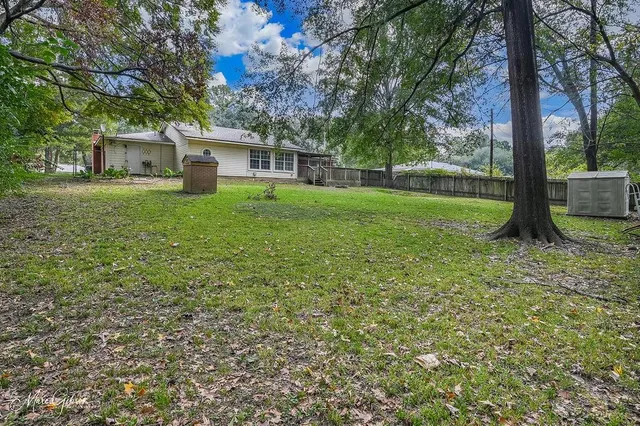 a view of a house with backyard and tree