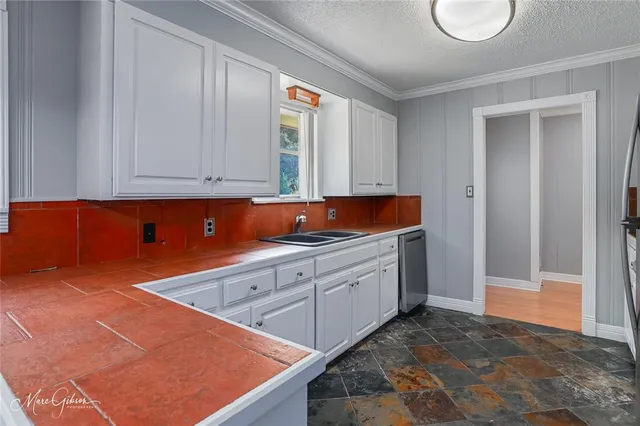 a kitchen with stainless steel appliances granite countertop a granite counter tops and a view of living room